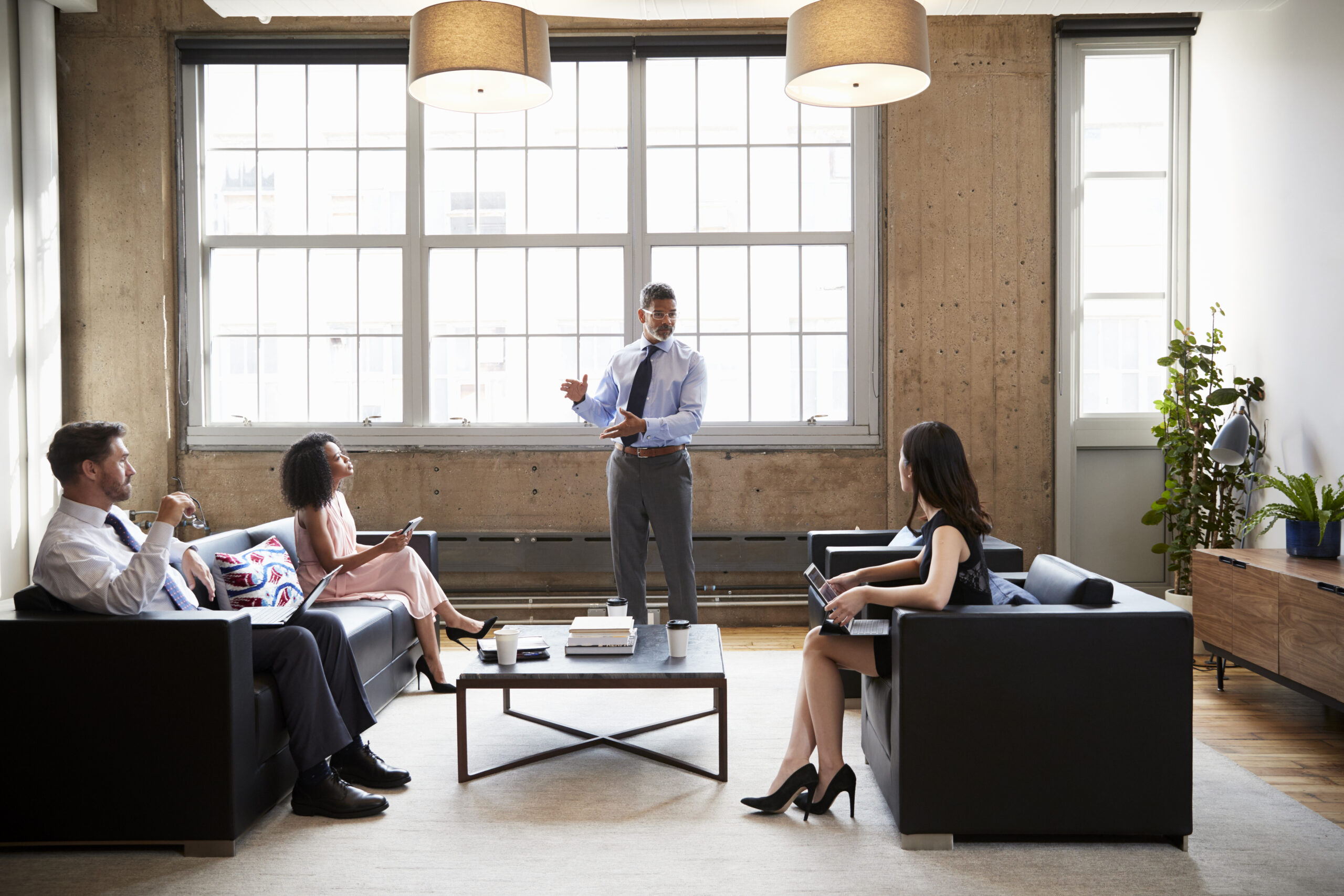 Male manager presenting at informal meeting in a lounge room